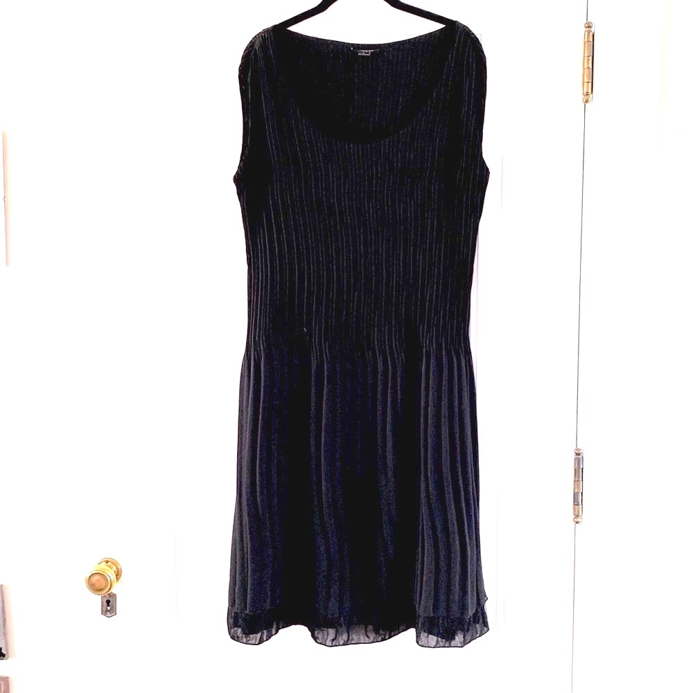 Sleeveless black dress with pleats and lacy hem